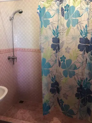 a shower curtain with flowers on it in a bathroom at Chambre cosy en bord de mer in Mohammedia