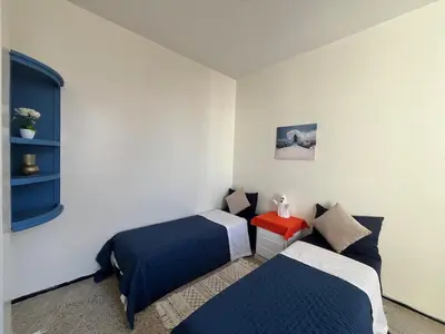 a bedroom with two beds and a red table at Chambre cosy en bord de mer in Mohammedia