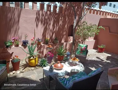 a patio with a table and potted plants at Kasbah de bouznika, style Marrakech avec jardin et piscine in Kasba Bou Hamira