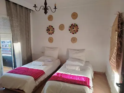 two beds sitting next to each other in a room at Appartement aéroport Mohammed 5 in Deroua