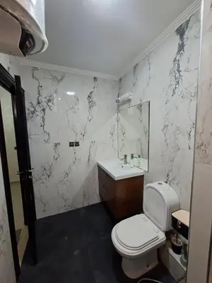 a white bathroom with a toilet and a sink at Appartement vu sur Mer in Mohammedia