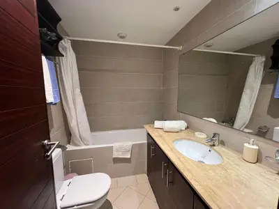 a bathroom with a sink and a toilet and a tub at Appartement Bouznika Bay Golf Beach in Bouznika