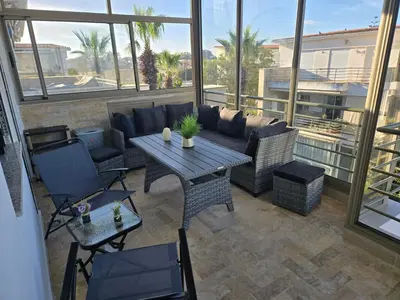 a patio with a couch and a table and chairs at Les perle de tamaris in Dar Mohammed Ould Haj Jilali