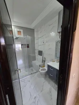 a bathroom with a shower and a toilet and a sink at Les perle de tamaris in Dar Mohammed Ould Haj Jilali