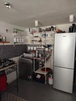 a kitchen with a white refrigerator and a stove at Cosy cabanon plage david in Kasba Bou Hamira