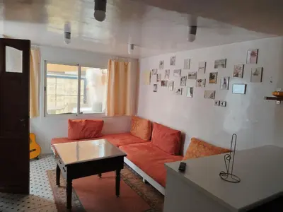 a living room with a couch and a table at Cosy cabanon plage david in Kasba Bou Hamira