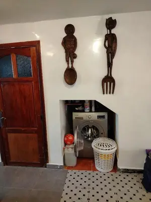 a room with a washing machine and a door at Cosy cabanon plage david in Kasba Bou Hamira