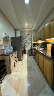 a large kitchen with wooden cabinets and a marble floor at Casablanca in Casablanca