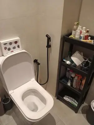a bathroom with a white toilet and a shelf at Blue Beach Residence Balnéaire pour familles in Sidi Rahal