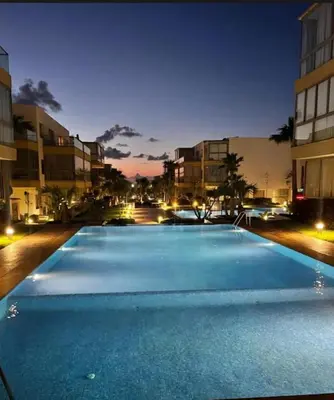 a large swimming pool in a city at night at Blue Beach Residence Balnéaire pour familles in Sidi Rahal