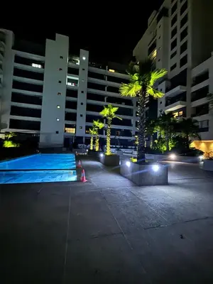 a swimming pool at night with palm trees and buildings at Morostay in Casablanca