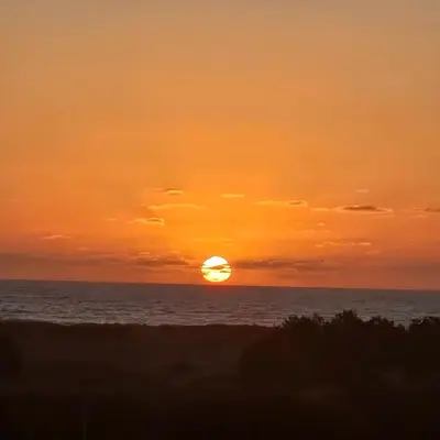 a sunset over the ocean with the sun in the sky at Appartement Moderne très bien équipé pour familles seulement- Résidence Garden Bay Dar Bouazza in Tamaris