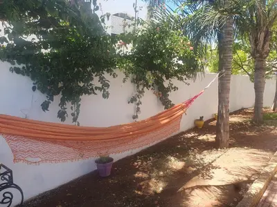 a hammock hanging on a wall in a yard at Villa plage david in Kasba Bou Hamira