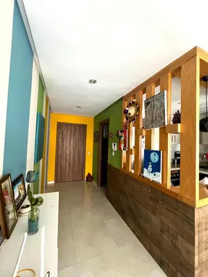 a room with yellow and green walls and a hallway at Appartement Chaleureux in Bouznika