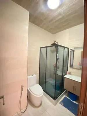 a bathroom with a shower and a toilet and a sink at Appartement dans une résidence fermée, Malaga Beach in Mohammedia