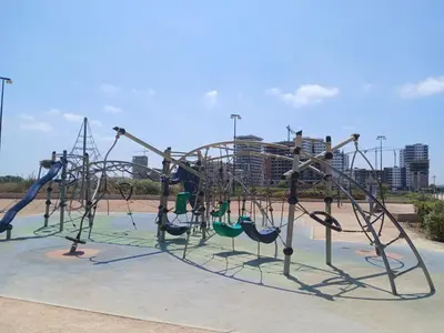 a playground with slides and swings in a park at Studio Cosy avec Mezzanine Piscine et Plage à 5 min à Zenata City in Aïn Harrouda