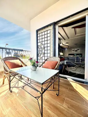 a living room with a table and chairs on a balcony at Rabat sidi yahya zaër in Sidi Yahia az Zaʼer