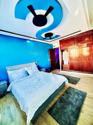 a bedroom with a large bed with a blue wall at Rabat sidi yahya zaër in Sidi Yahia az Zaʼer