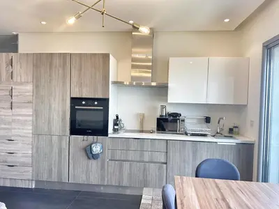 a kitchen with white cabinets and a table in a room at Ocean Dream in Casablanca