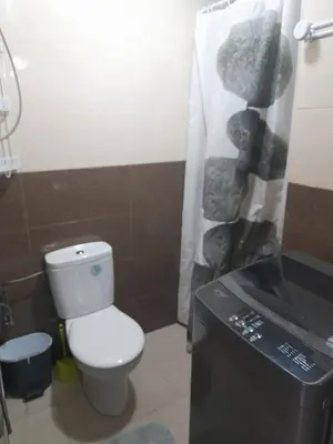 a bathroom with a white toilet and a black sink at La cascade 2 in Sidi Rahal