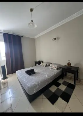 a bedroom with a bed and a table in it at Un charmant Studio Meublé a Casablanca Maarif in Casablanca