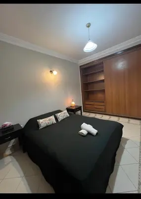 a bedroom with a black bed with two towels on it at Un charmant Studio Meublé a Casablanca Maarif in Casablanca