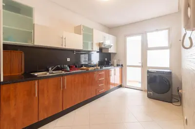 a kitchen with wooden cabinets and a large window at NEW - 2CH Val d'Anfa Triangle d'Or - Fibre Optique in Casablanca
