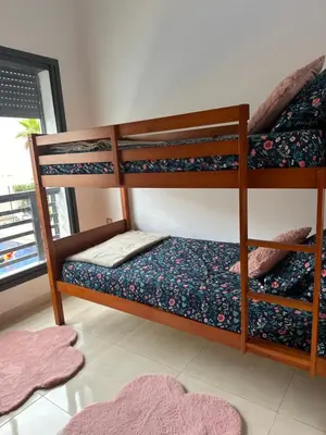 a room with two bunk beds with a rug at Appartement calme in Bouznika