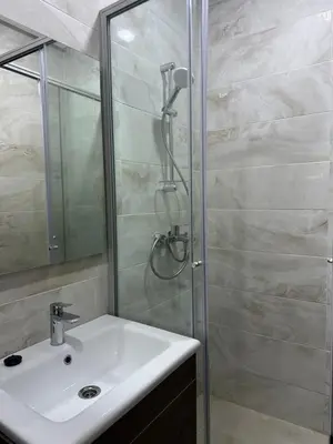 a bathroom with a sink and a shower at Appartement calme in Bouznika