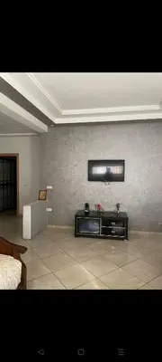 a living room with a tv on a wall at Sidi rahal apartment in Sidi Rahal