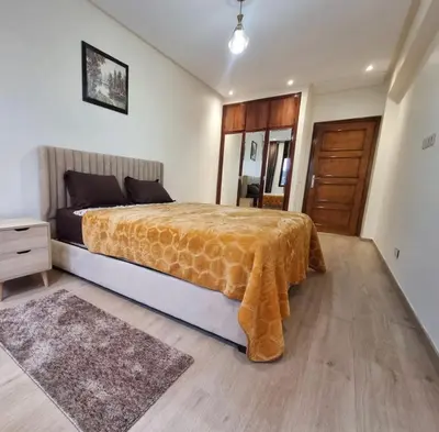 a bedroom with a bed and a wooden door at Modern gated apartment 2 bedroom 2 baths Beachside with pool in Casablanca