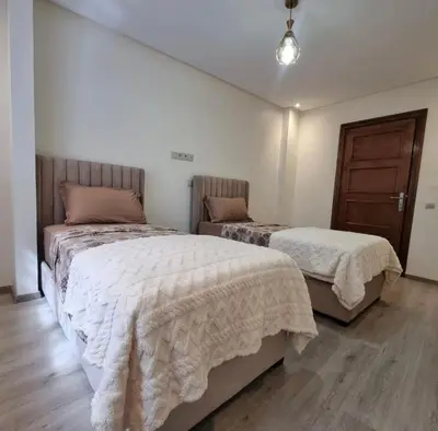 a bedroom with two beds with white comforters at Modern gated apartment 2 bedroom 2 baths Beachside with pool in Casablanca