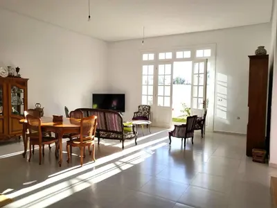 a living room with a table and chairs at villa dans el mansouria in Mansouria