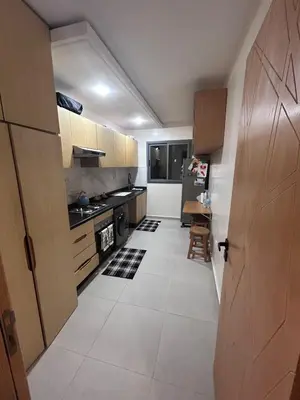 a kitchen with a large white tile floor at Appartement élégant et raffiné in Nouaseur