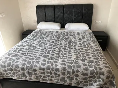 a bed with a black and white comforter on it at Sable d or in O Ben Slimane