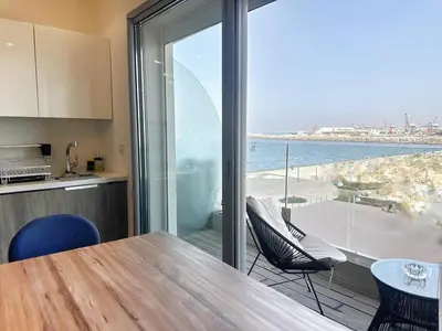a kitchen with a table and chairs and a view of the ocean at 1-Marina Luma oceane-terrasse sur mer in Casablanca