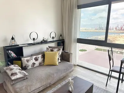 a living room with a couch and a large window at 3-marina Serena ocean-studio chic vue mer in Casablanca