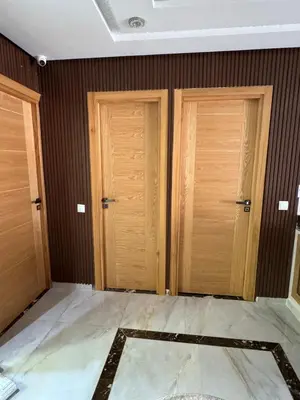 a room with three wooden doors and a tile floor at Apartment with pool view in Mansouria