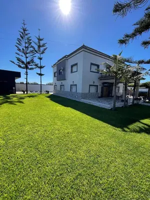 a white building with the sun in the sky at Villa Royale Prestige Safaa in Dar Bouazza