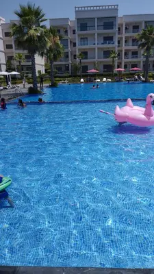 a swimming pool with a pink float in the water at Appartement à louer à Bouznika avec piscine in Bouznika