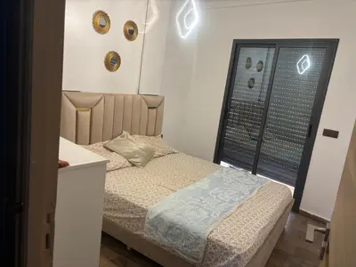 a small bedroom with a bed and a window at Cozy apartment near the airport in Deroua