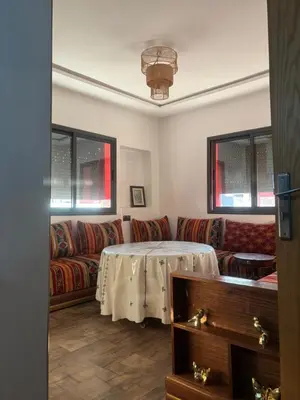 a living room with a table and a couch at Cozy apartment near the airport in Deroua