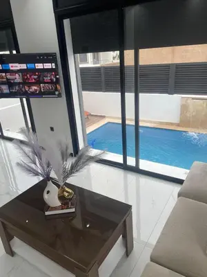 a living room with a coffee table and a pool at Villa Chez Badre with Pool High Standing in Sidi Rahal