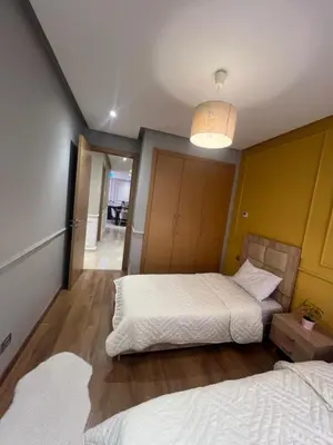 a bedroom with two beds and a hallway at Appartement Élégance Cosy in Rabat