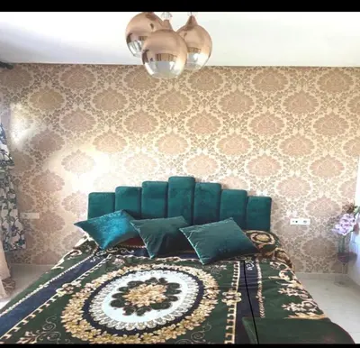 a bedroom with a bed with a green head board at Mohmmadia puerto banus in Mohammedia