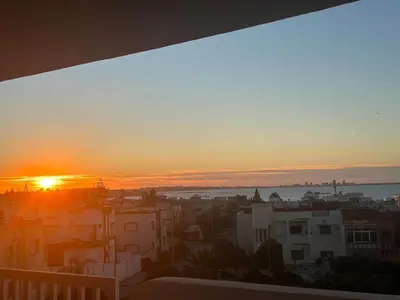 a sunset over a city with buildings and the ocean at La siesta beach resort Mohammedia vue mer panoramique in Mohammedia