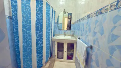 a bathroom with a sink and blue tiled walls at Immense appartement familial vue sur mer in Rabat