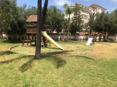 a playground with a yellow slide in a park at Apartment Galia Mohammedia in Mohammedia