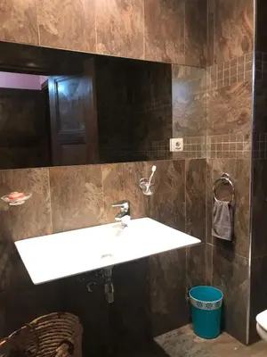 a bathroom with a white sink and brown tiles at Apartment Galia Mohammedia in Mohammedia