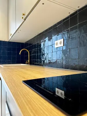 a kitchen with a sink and blue tiles at An Elegant apartment, Quiet Stay with Moroccan Touch in Dar Bouazza